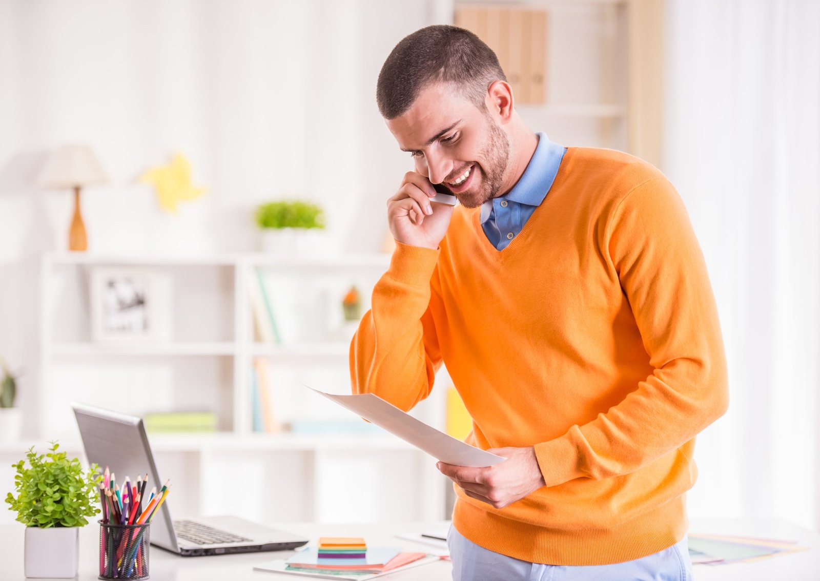 Person talking on his phone with a letter in his hand trying to crack a deal. Booomrcial is the best digital marketing agency in Gurgaon